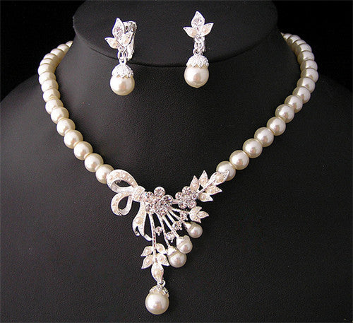 Elegant pearl necklace and matching drop earrings set with rhinestone bow and floral accents, ideal for bridal wear. - Image 2