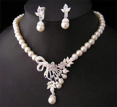 Elegant pearl necklace and matching drop earrings set with rhinestone bow and floral accents, ideal for bridal wear. - Image 2