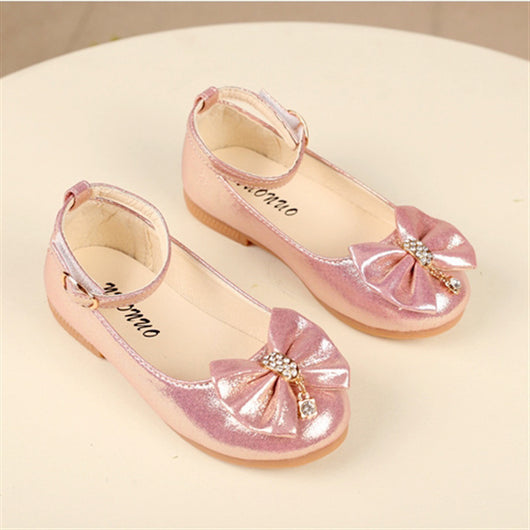 Shiny pink children's ballet flats with ankle straps, decorative bows, and rhinestone embellishments. - Image 4