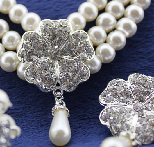 Three-piece pearl jewelry set with multi-strand necklace, bracelet, and drop earrings, all featuring sparkling rhinestone flower accents. - Image 3