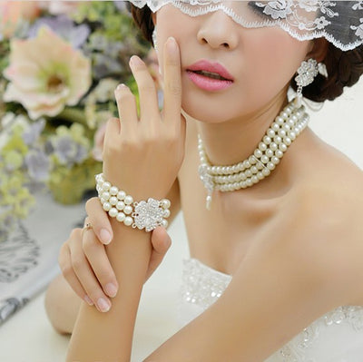 Three-piece pearl jewelry set with multi-strand necklace, bracelet, and drop earrings, all featuring sparkling rhinestone flower accents. - Image 4