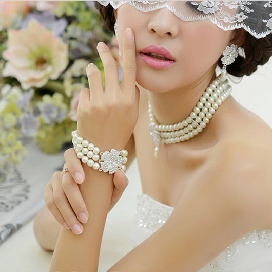 Three-piece pearl jewelry set with multi-strand necklace, bracelet, and drop earrings, all featuring sparkling rhinestone flower accents. - Image 4