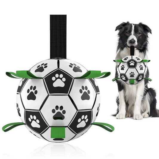 Interactive dog football toy with black and white panels, paw prints, green nylon tabs, and a green carabiner clip. Includes a black inflation pump.