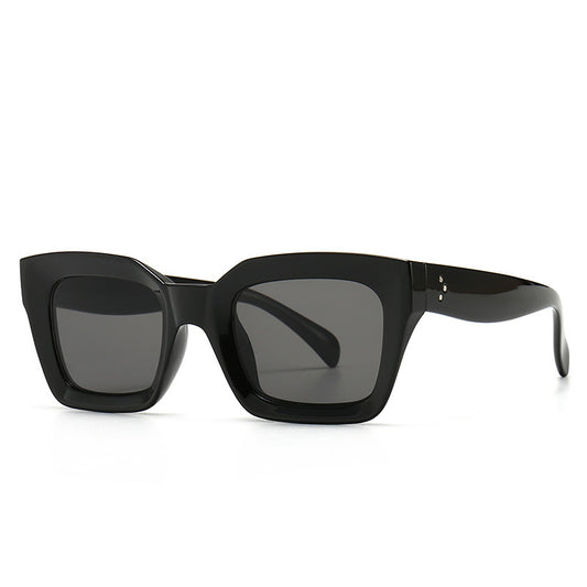 Clear square-framed glasses with a vintage style, featuring a plastic and metal frame and resin lenses.