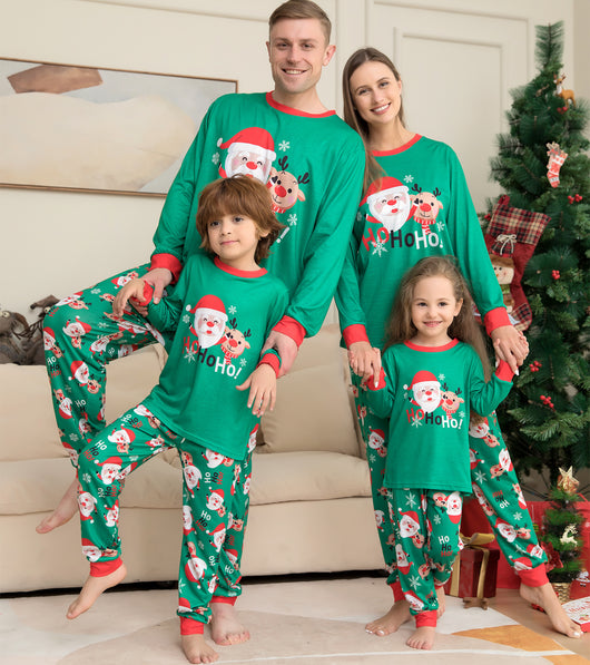 Family of four wearing matching green Christmas pajamas with Santa Claus and reindeer print, sitting on a sofa. - Image 17