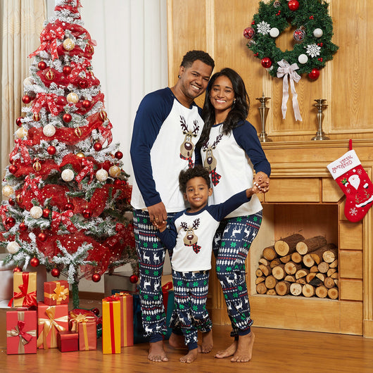 Family of three wearing matching Christmas pajamas with reindeer tops and snowflake-patterned pants. - Image 2
