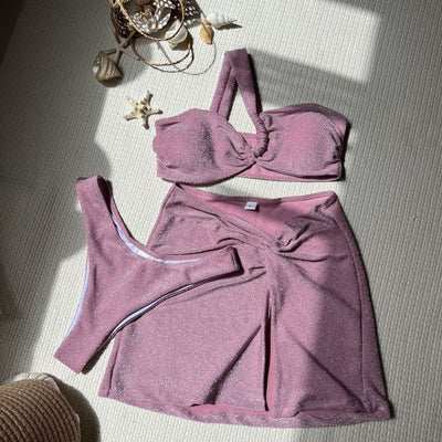 Pink shimmery three-piece swimsuit with a one-shoulder tube top, high-cut bikini bottom, and matching mini skirt. - Image 15