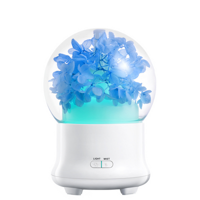 White aromatherapy machine with a clear dome top, featuring blue preserved flowers and an aqua glow. Includes 'LIGHT' and 'MIST' controls. - Image 9
