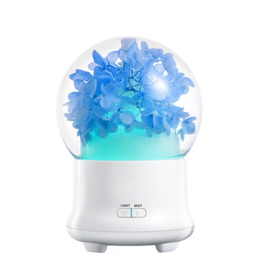 White aromatherapy machine with a clear dome top, featuring blue preserved flowers and an aqua glow. Includes 'LIGHT' and 'MIST' controls. - Image 9