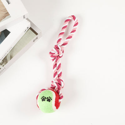 Red, pink, and white braided cotton rope dog toy with a green and red tennis ball featuring black paw prints. - Image 9