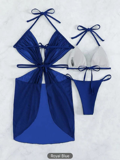 White three-piece halter neck bikini and sheer cover-up set with a heart-shaped embellishment, laid flat on wood. - Image 16