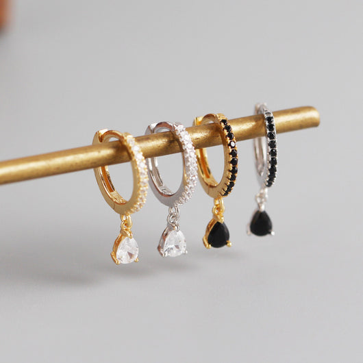 Silver-colored hoop earrings with black pave stones and dangling black teardrop-shaped stones. - Image 4