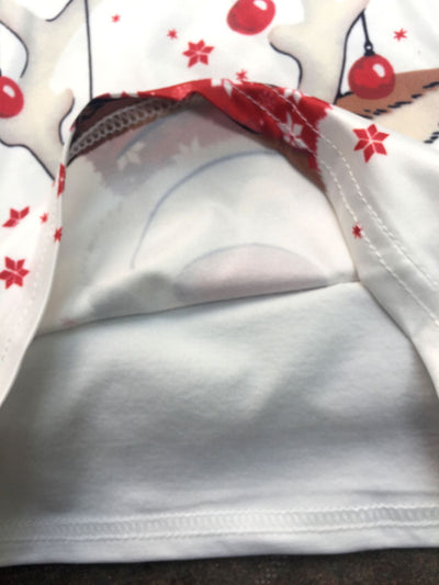 Family of four and a golden retriever wearing matching white long-sleeve reindeer tops and red plaid pajama pants. - Image 21