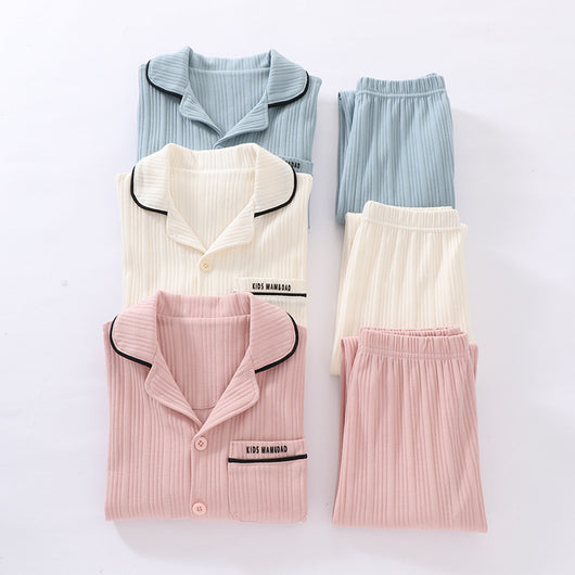 Beige ribbed cotton children's pajama set with long-sleeved lapel top and matching pants, featuring black trim. - Image 2
