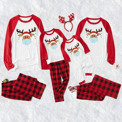 Matching family Christmas pajamas with grey tops, red plaid sleeves, and a reindeer wearing a Santa hat and face mask.