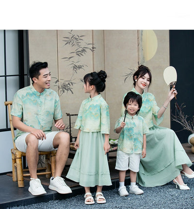Mother and daughter in matching light green Chinese style cheongsam suits with patterned tops and solid skirts. - Image 11