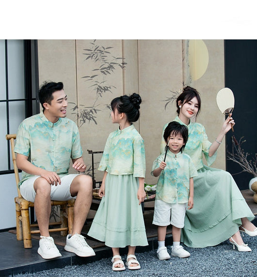 Mother and daughter in matching light green Chinese style cheongsam suits with patterned tops and solid skirts. - Image 11