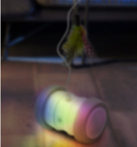 Automatic cat teasing toy with a white roller base and gray wheels, featuring a colorful feather attachment. - Image 4