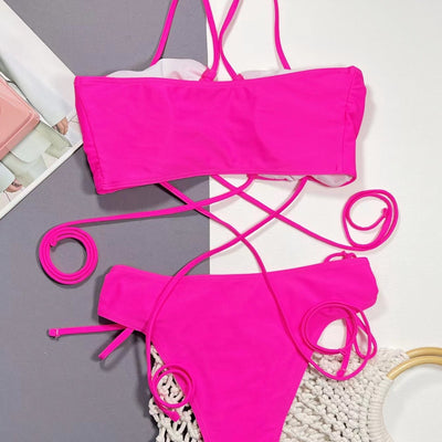 Neon pink lace-up bikini with a bandeau top and high-cut bottom, laid flat on a split gray and white background. - Image 3