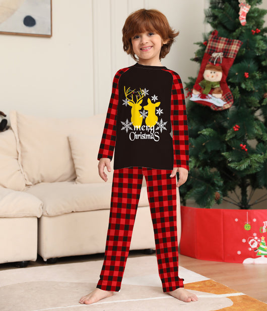 Two children in matching black and red buffalo plaid Christmas pajamas with golden deer and "Merry Christmas" print. - Image 4