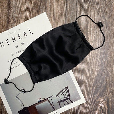 Light pink double layer silk face mask with adjustable white ear loops on an open magazine. - Image 29