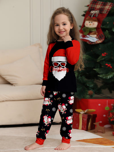 Woman wearing a black and red Christmas pajama set with a Santa Claus graphic top and snowman-patterned pants. - Image 8
