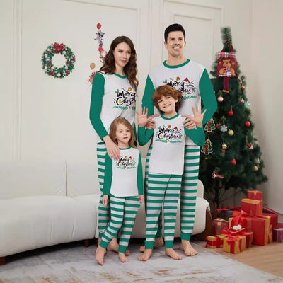 Family of four wearing matching green and white striped Christmas pajamas with "Merry Christmas" graphic.
