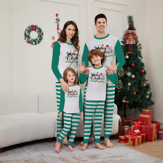 Family of four wearing matching green and white striped Christmas pajamas with "Merry Christmas" graphic.