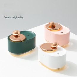 Dark green and rose gold rotating planet humidifier with a clear water tank and a wooden planet-like top. - Image 3
