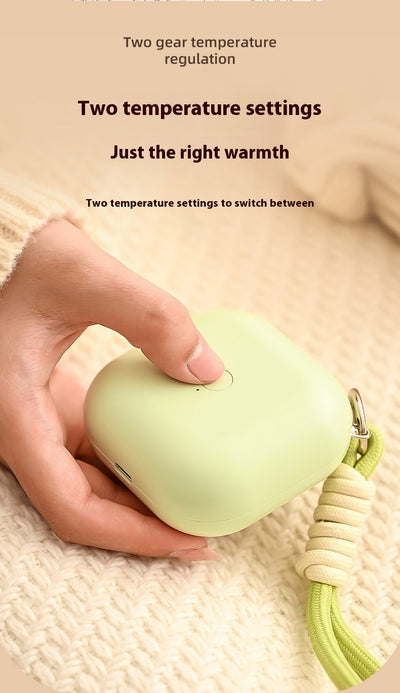 Light green square hand warmer with rounded corners and a black smiley face, hanging from a two-tone lanyard. - Image 14