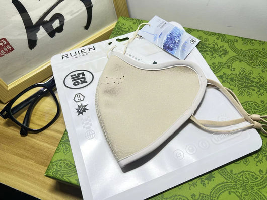 Dark gray cotton head-mounted mask with adjustable ear loops, shown in packaging on a patterned green surface. - Image 18