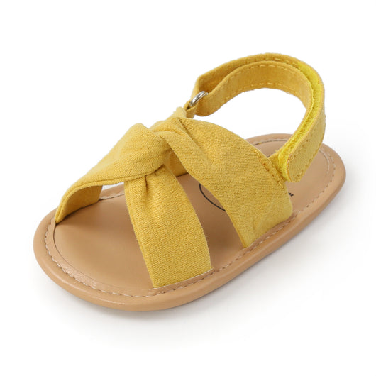 Black baby sandals with knotted cross straps and a matching black floral headband on a white background. - Image 28