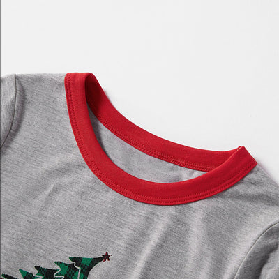 Family of four wearing matching gray long-sleeve pajamas with red truck and Christmas tree graphic, red and black plaid pants. - Image 4