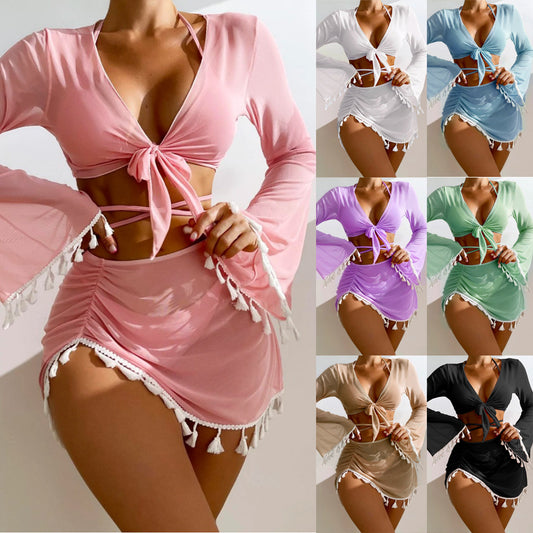 Light blue four-piece swimsuit set with a tie-front long-sleeve blouse, bikini top, and ruched mesh skirt with white tassels.