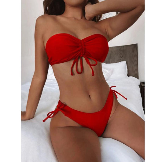Red two-piece bikini with a strapless ruched bandeau top and matching side-tie bottoms, displayed on a white surface. - Image 12
