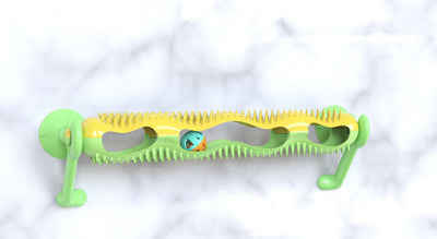 Grey tabby kitten playing with a yellow and teal wall-mounted cat toy featuring a track with rolling balls. - Image 11
