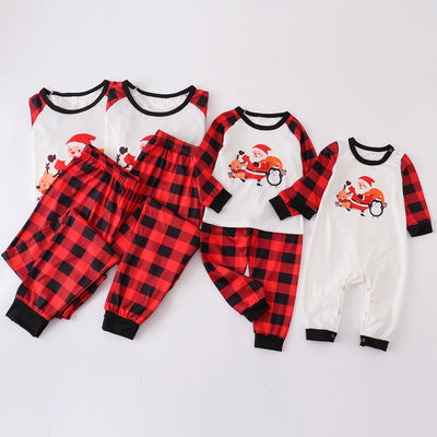 Christmas pajama set with a white long-sleeve top featuring Santa, reindeer, and penguin, and red and black plaid pants. - Image 4