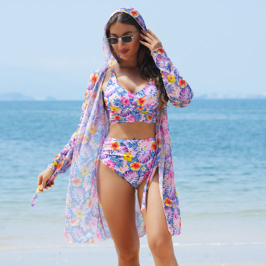 Woman in a red multicolor floral print three-piece swimsuit with high-waisted bikini and long-sleeve cover-up, straw hat, and sunglasses on a beach. - Image 10