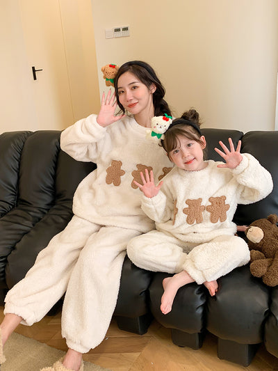 Mother and child in matching off-white coral velvet pajamas with brown cartoon bears, sitting on a black couch. - Image 4