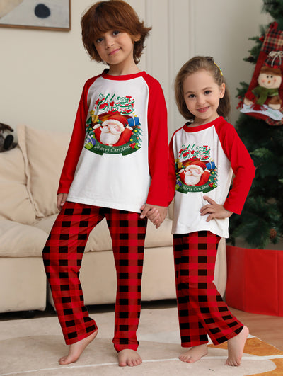 Man in a red and white Christmas pajama set with a Santa Claus graphic top and red and black plaid pants. - Image 4