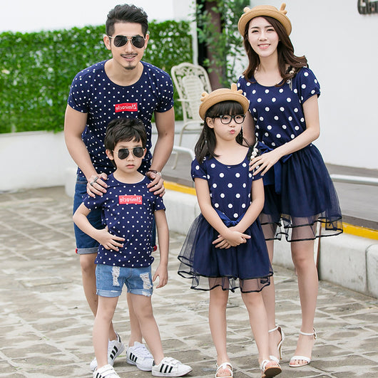 Family of four wearing matching white and black polka dot outfits. Dad and son in t-shirts, mom and daughter in dresses. - Image 7