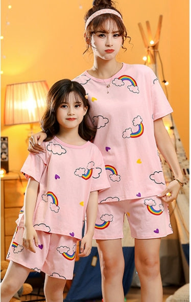 Mother and daughter wearing matching pink cotton short-sleeved pajama sets with rainbow and cloud patterns. - Image 2