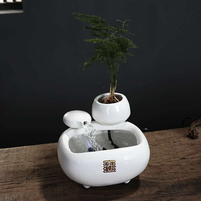 White ceramic flowing water fountain ornament with an integrated planter holding a green plant. Features gold Chinese characters. - Image 4