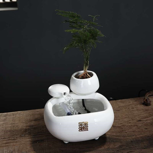 White ceramic flowing water fountain ornament with an integrated planter holding a green plant. Features gold Chinese characters. - Image 4