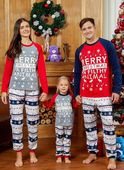 Family of three wearing matching Christmas pajamas with "Merry Christmas Ya Filthy Animal" print and festive patterns.