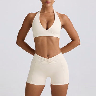 Light pink halter neck sports bra and high-waisted leggings workout set on a model. - Image 15