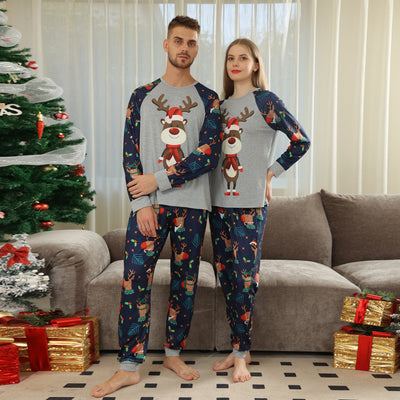 Family Christmas pajamas with a cartoon reindeer wearing a Santa hat and red scarf on a black top, and dark blue pants with a repeating reindeer and holly patte - Image 16