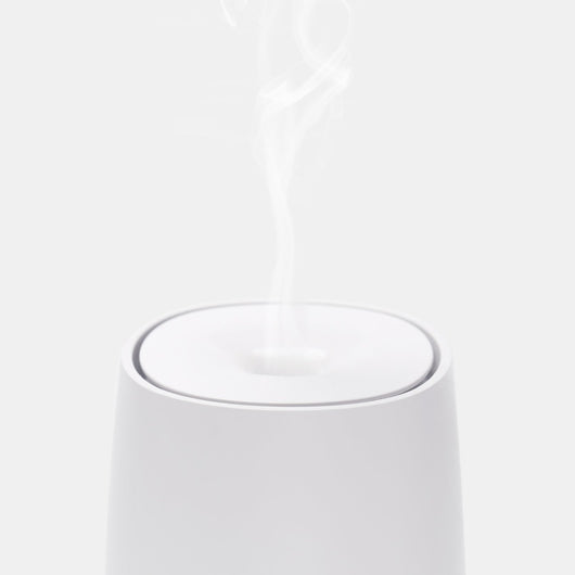 White mini aromatherapy machine with a minimalist design, featuring a top mist outlet and a single control button. - Image 2