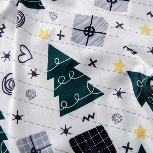 Family of four in matching red and green Christmas pajamas with tree and gift prints, mother holds baby romper. - Image 14