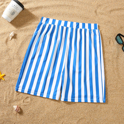 Blue and white striped one-piece swimsuit with a bow detail on the bust, laid on sand with sunglasses. - Image 6